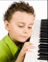 Small boy pressing piano keys